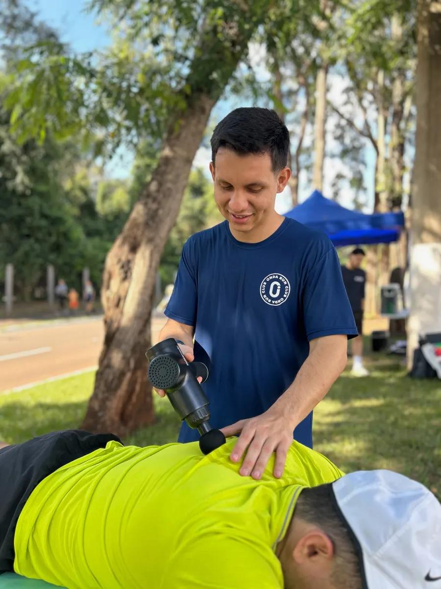 Recuperação muscular com massagem na beira da pista, em treino do Onda Run Club